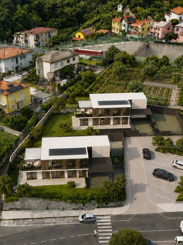 Vista dall'alto del lotto con i due volumi, i giardini e i parcheggi